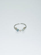 Silver wrapped Ring with Pearl in the middle and two light blue beads on two sides on a white background.