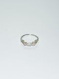 Silver wrapped Ring with Pearl in the middle and two pink beads on two sides on a white background.