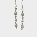 Pair of pearl link earrings on a gray background