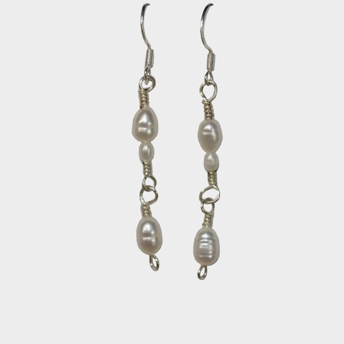 Pair of pearl link earrings on a gray background