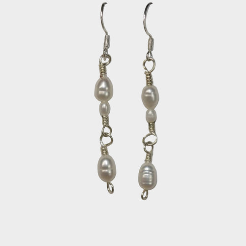 Pair of pearl link earrings on a gray background