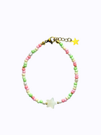 A star-shaped mother of pearl bracelet colourful (pink, green and beige) beads on a white background.