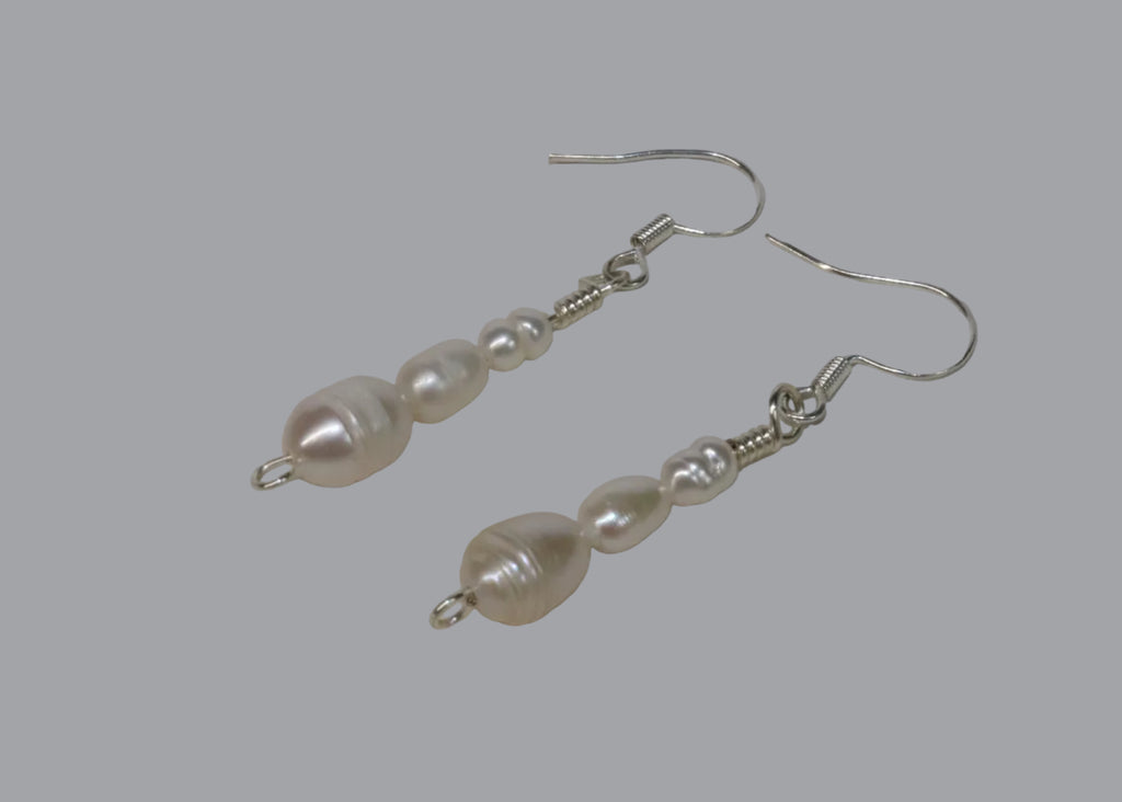 Pearl earrings on a light gray surface
