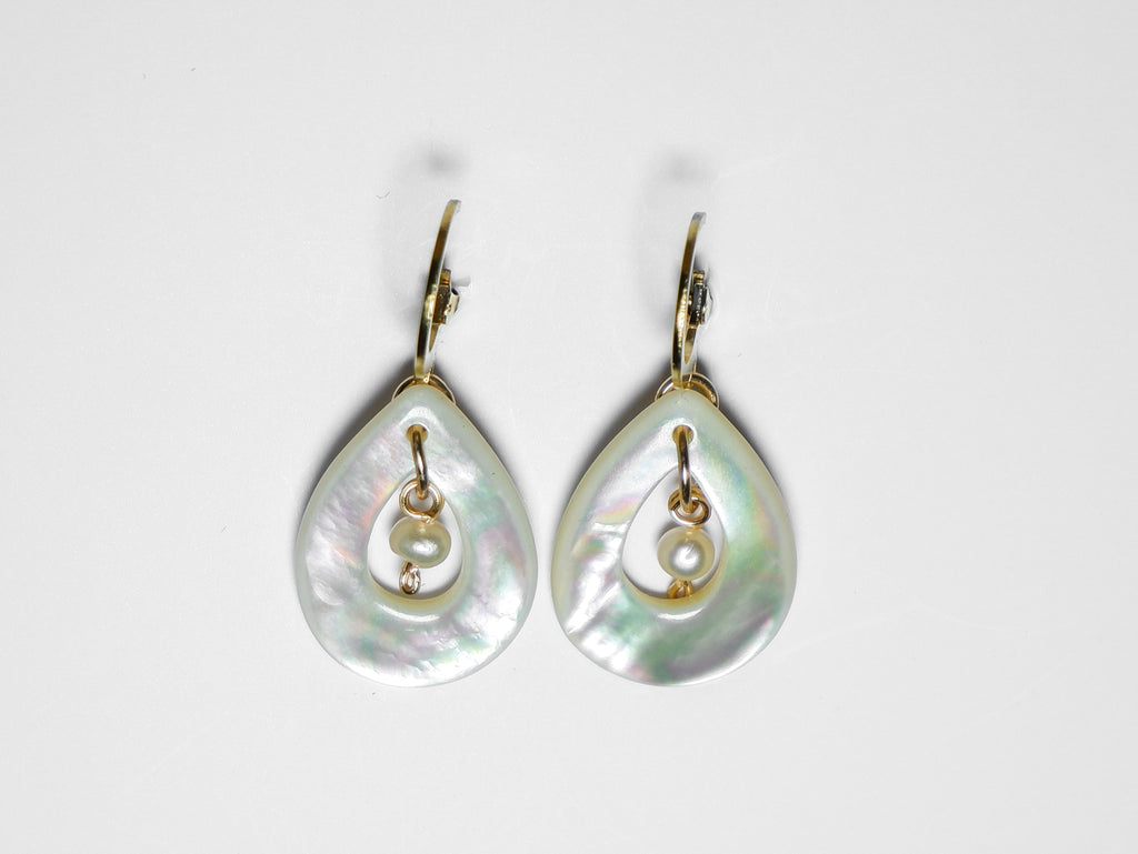 A close-up horizontal shot of gold earrings with teardrop-shaped mother of pearl with pearl in the middle on a white background.