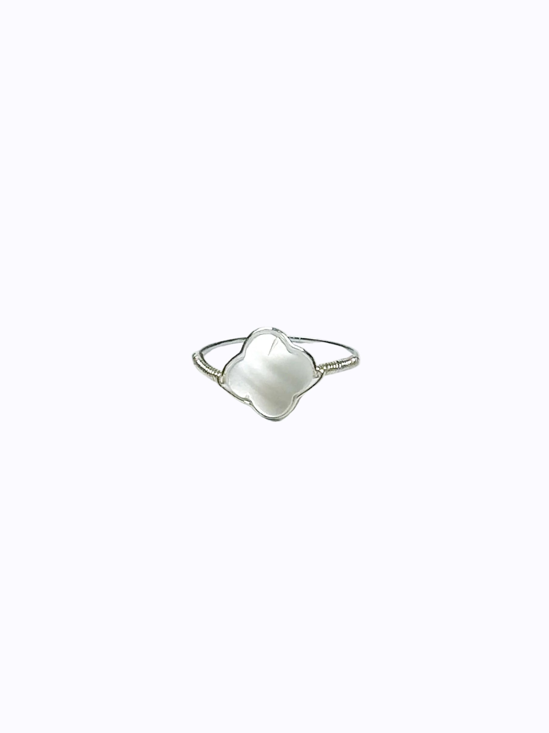 Silver wrapped ring with clover-shaped mother of pearl on the white background.