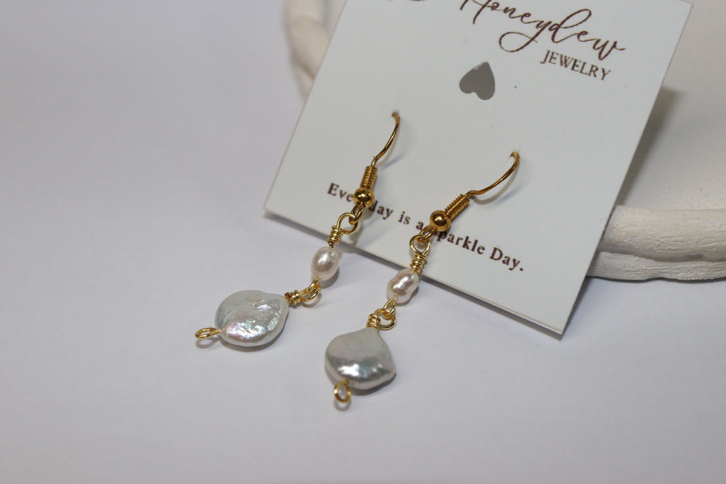 Pearl and gold earrings on a Honeydew Jewellery card with a white background