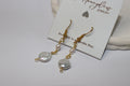 Pearl and gold earrings on a Honeydew Jewellery card with a white background