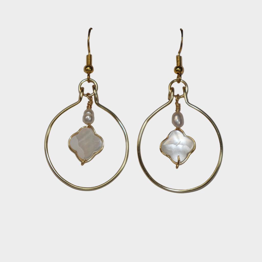 Gold hoop earrings with central stone on a light gray background