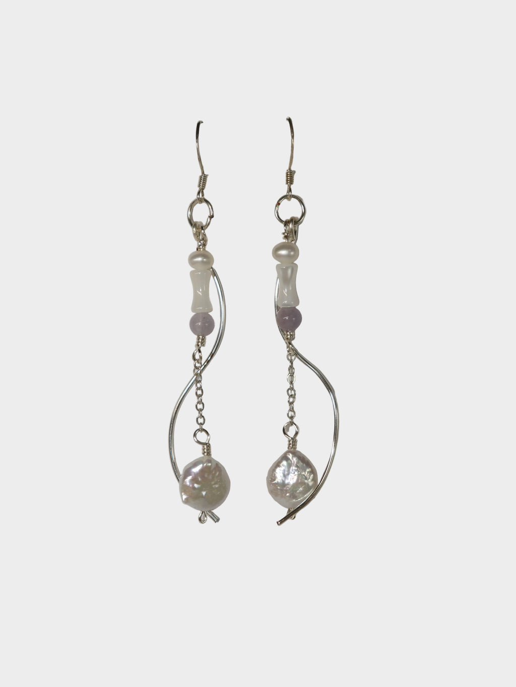 Silver-plated pair of earrings with silver-plated hooks. The body consists of a pearl, a cone-shaped mother of pearl, and a purple bead, connected by a chain and round, plate-shape pearl at the tail. A separate curvy metal body also follow along the main body.