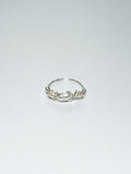Silver Wrapped Ring with three Pearls in the middle on a white background with shadows.