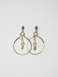 Gold hoop pearl earrings on a light grey background.