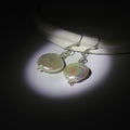 Large Round pearl earrings on a dark background. Using spotlight effect, the earrings has a pearlescent effect illuminating them.