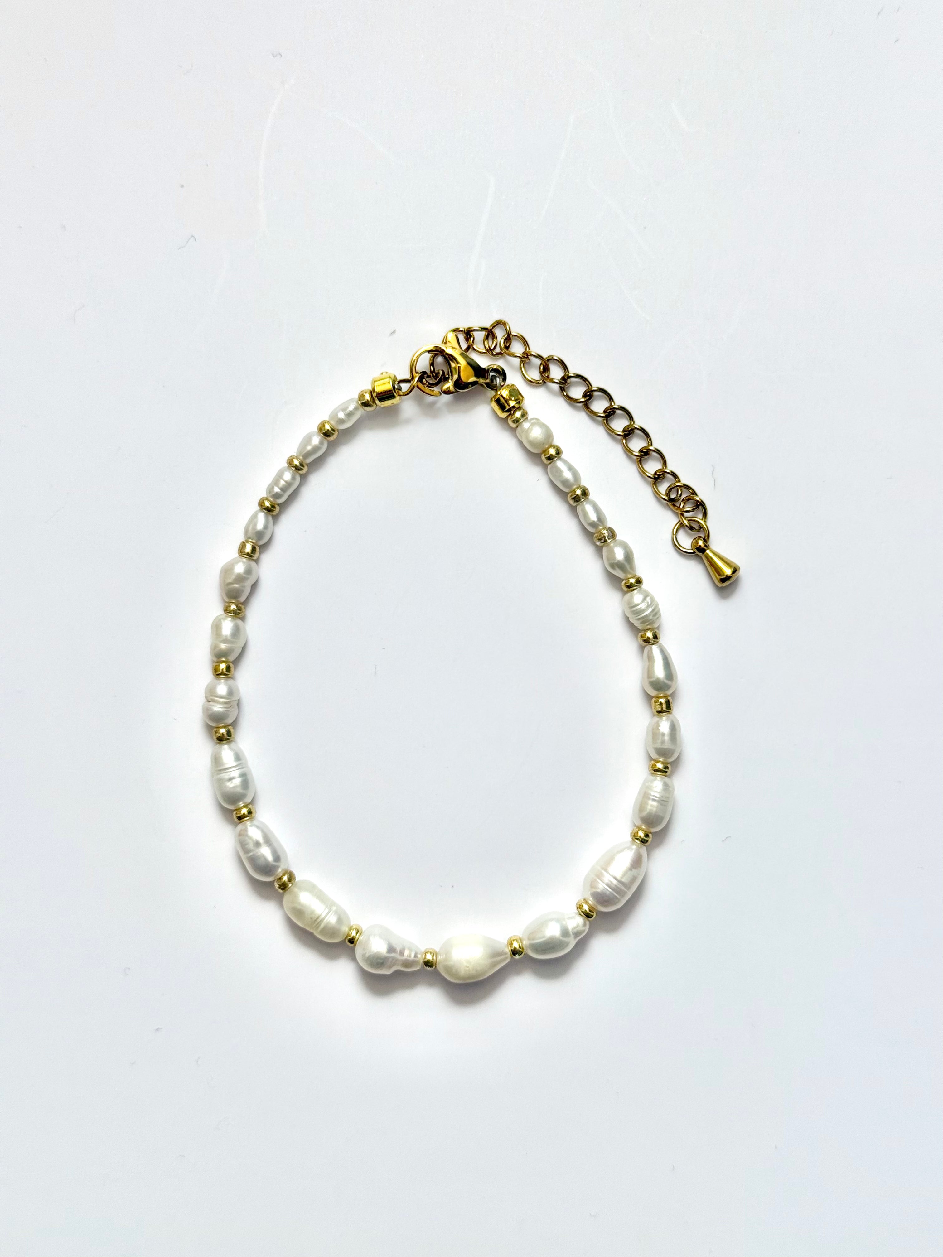 Premium, full pearl bracelet with gold accents on a white background.