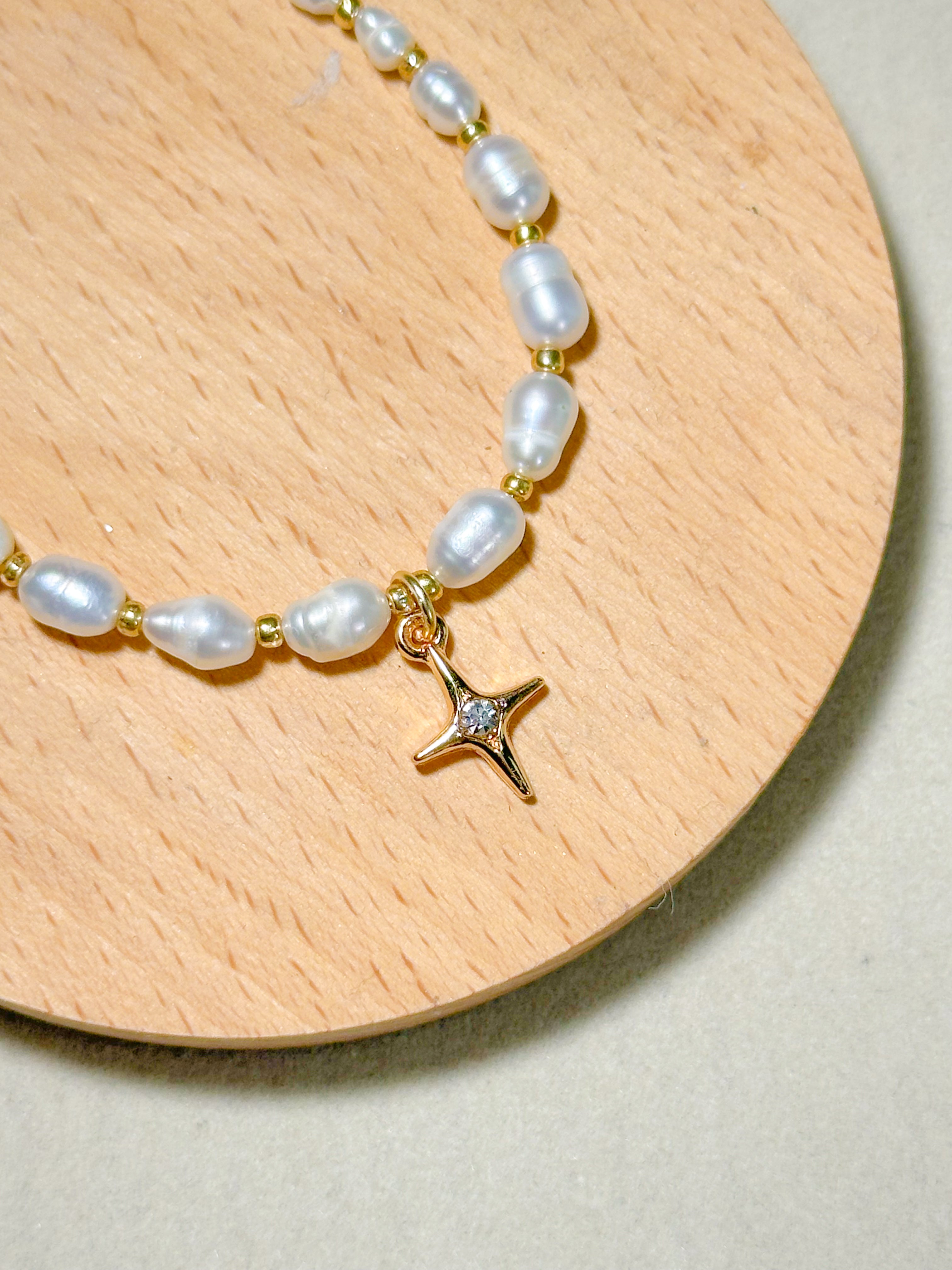 Premium pearl bracelet with a star-shaped pendant on a wooden board