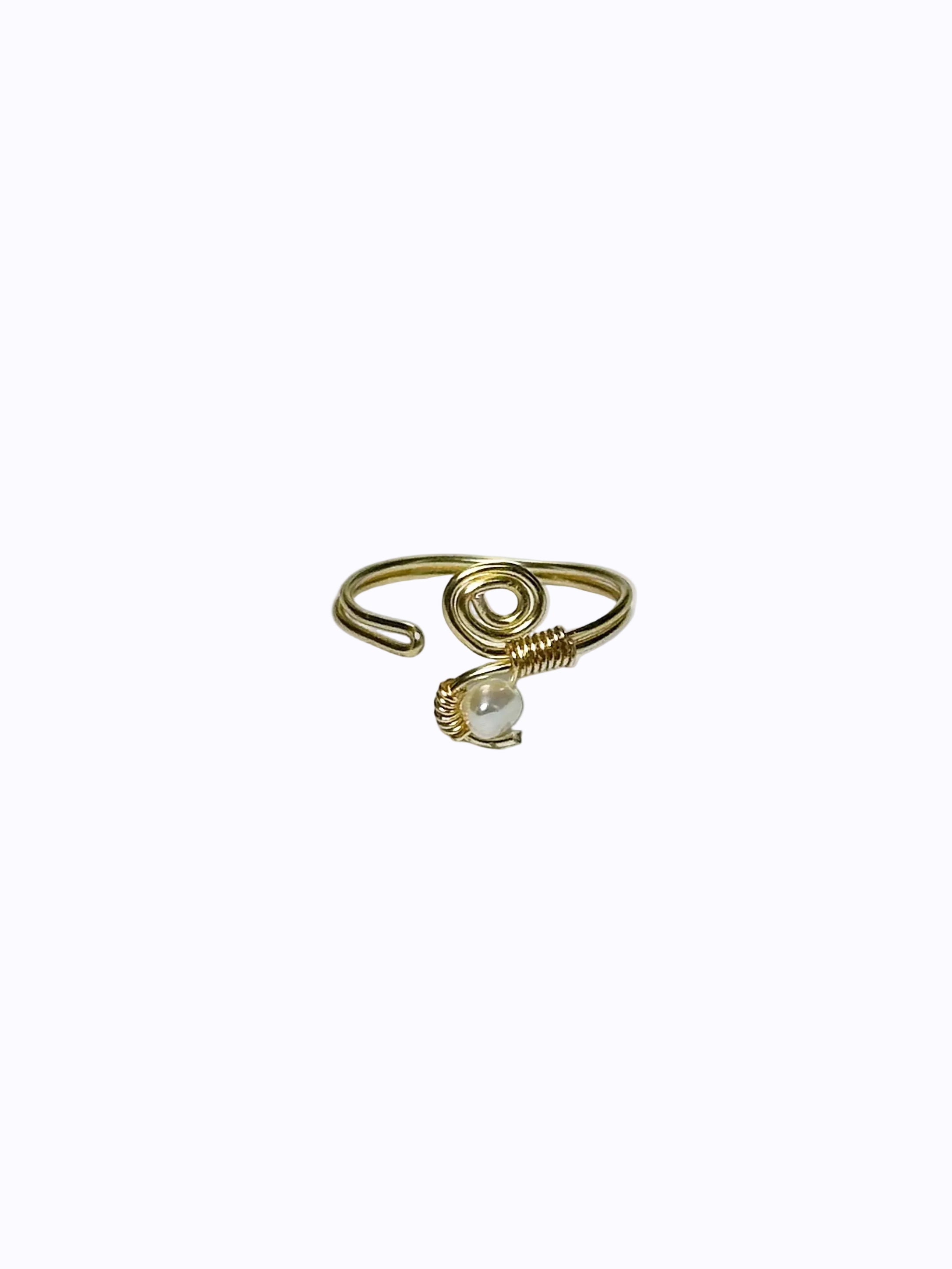 Gold wrapped ring with a twirl-top and pearl-bottom face, open design, on a white background.