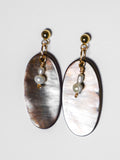 An ultra close-up shot of a gold earrings with pearl and an oval-shaped abalone mother of pearl on a white background.